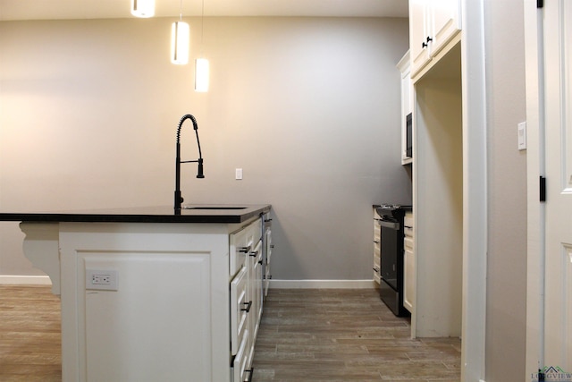 kitchen featuring black range with electric stovetop, white cabinetry, sink, light hardwood / wood-style floors, and decorative light fixtures