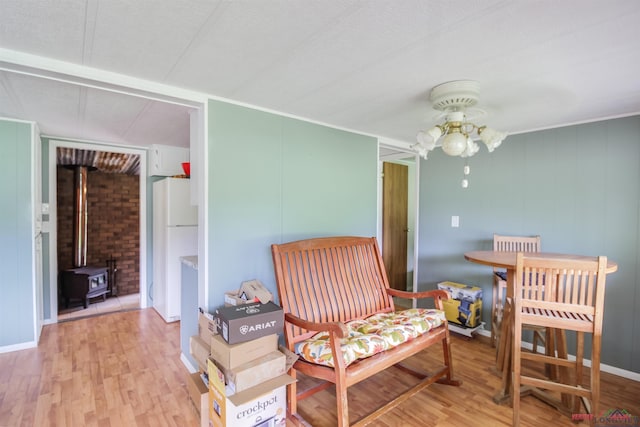 bedroom featuring hardwood / wood-style flooring, white refrigerator, and a wood stove