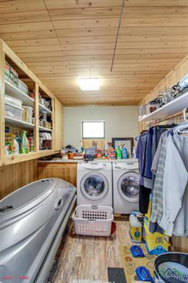 clothes washing area featuring hardwood / wood-style floors, separate washer and dryer, and wooden ceiling