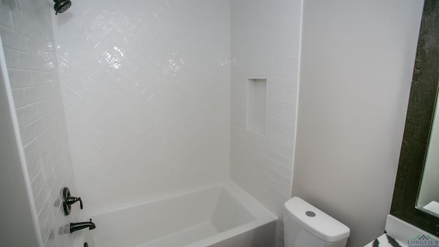 bathroom featuring toilet and tiled shower / bath