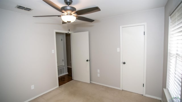 unfurnished bedroom with ceiling fan, light colored carpet, and multiple windows