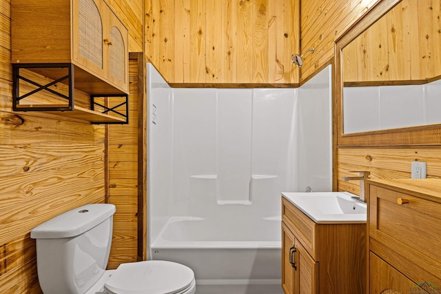 full bathroom with wood walls, vanity, shower / bathtub combination, and toilet