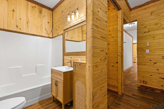 full bathroom featuring vanity, bathing tub / shower combination, toilet, and wood walls