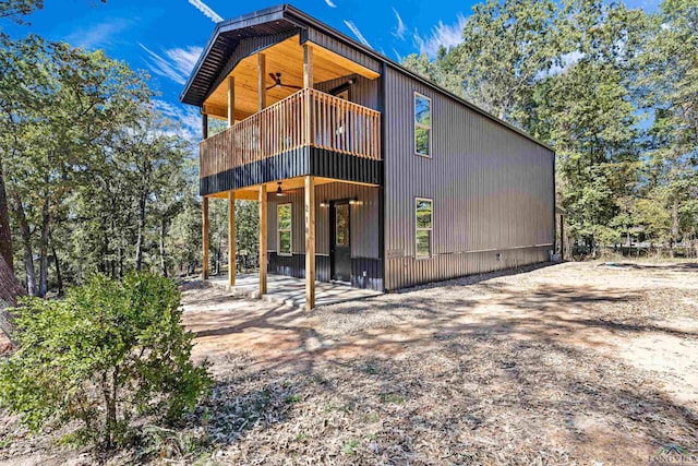 rear view of property featuring ceiling fan and a patio area