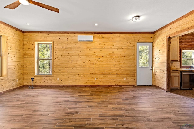 spare room featuring hardwood / wood-style floors, ceiling fan, wood walls, and a wall mounted AC