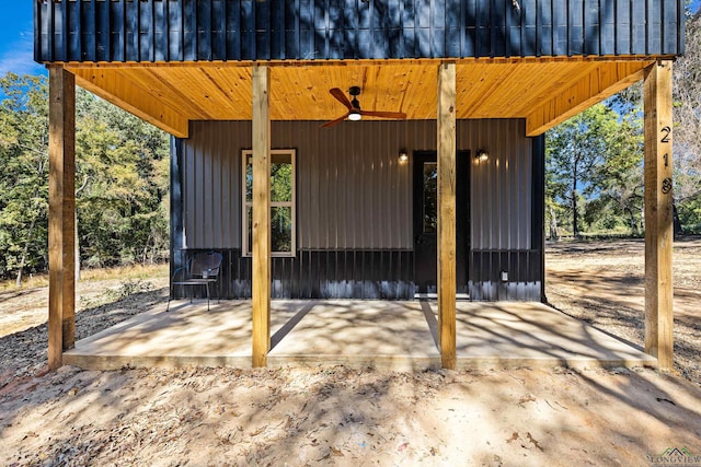 view of gate with ceiling fan and a patio area