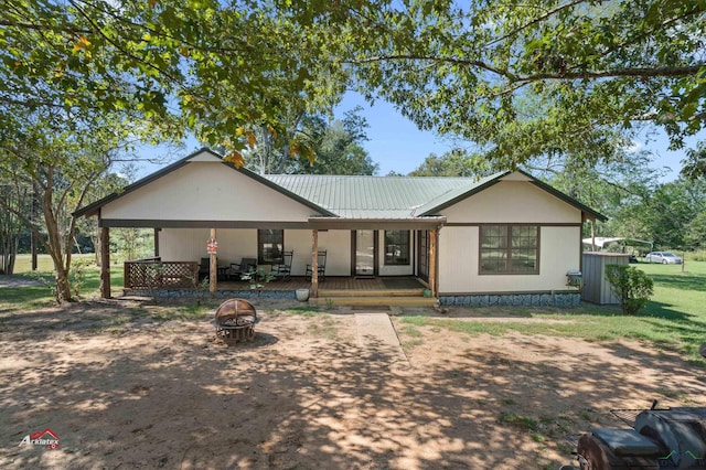 single story home with a porch and an outdoor fire pit