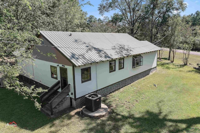 rear view of house with a lawn and cooling unit