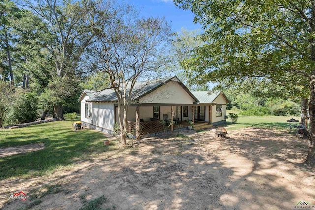 view of front facade with an outdoor fire pit and a front yard