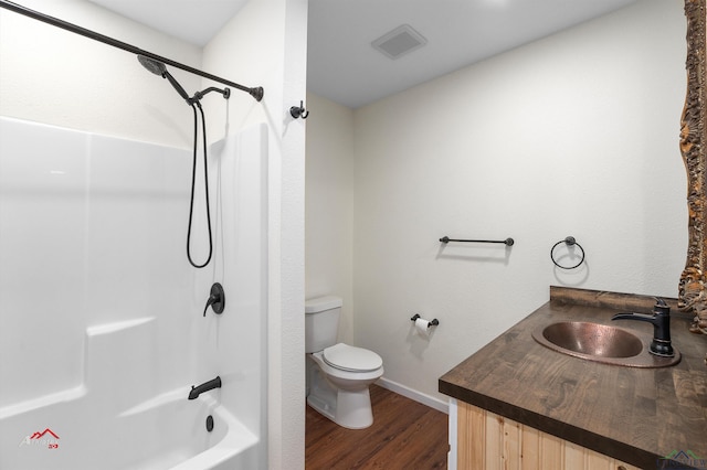 full bathroom with hardwood / wood-style floors, vanity,  shower combination, and toilet