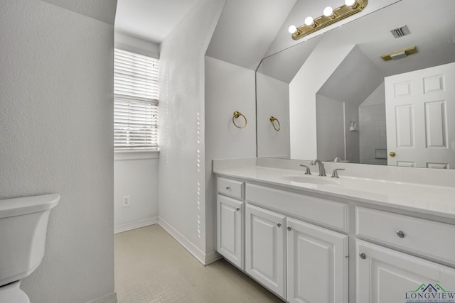 bathroom with vanity, vaulted ceiling, and toilet