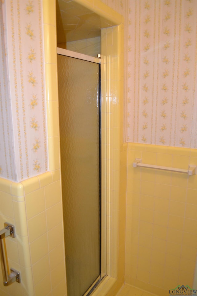 bathroom with tile walls and an enclosed shower