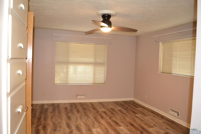 empty room with dark hardwood / wood-style floors and ceiling fan