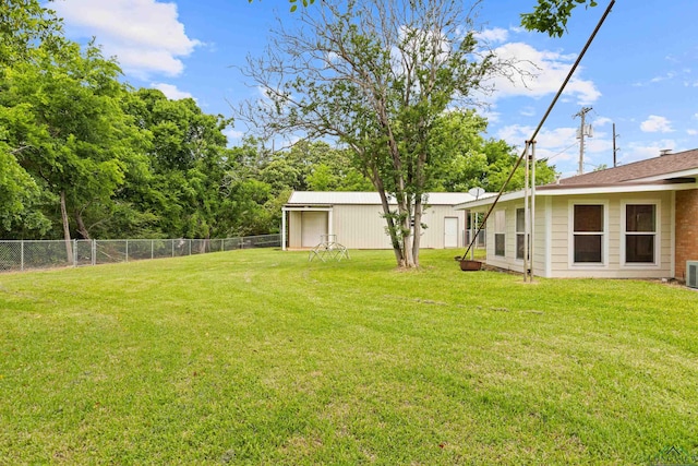 view of yard featuring central AC, fence, and an outdoor structure