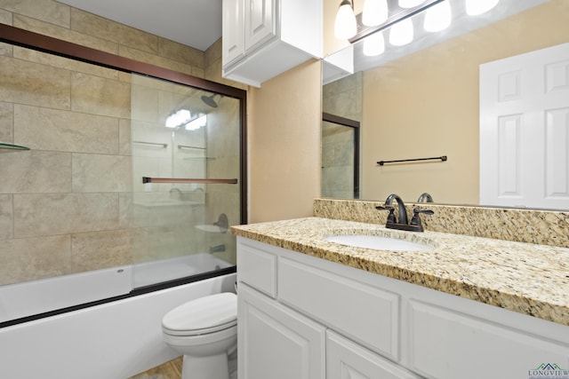 full bath with vanity, combined bath / shower with glass door, and toilet