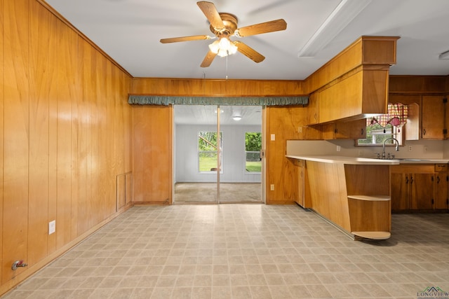 kitchen featuring light countertops, wood walls, and light floors