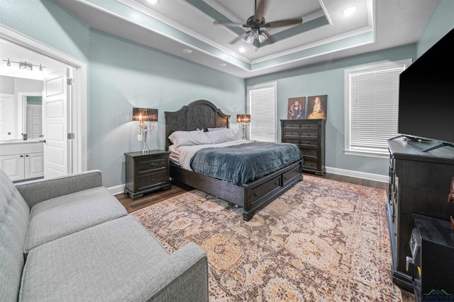 bedroom featuring recessed lighting, dark wood-style floors, connected bathroom, a raised ceiling, and baseboards