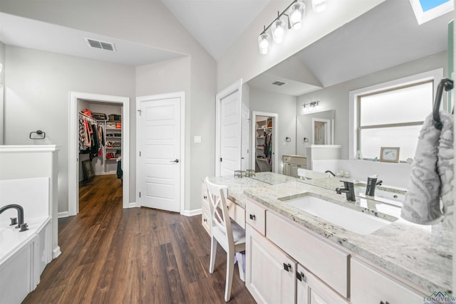 bathroom featuring vanity, visible vents, wood finished floors, and lofted ceiling