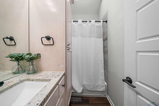 bathroom featuring vanity, baseboards, wood finished floors, and shower / bath combination with curtain