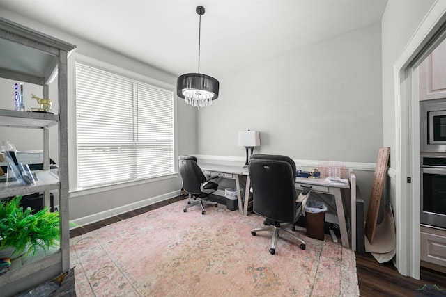 office area featuring dark wood finished floors, baseboards, and an inviting chandelier