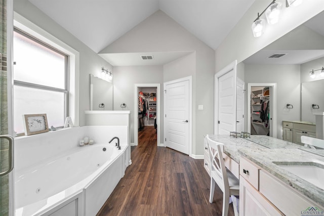 full bathroom featuring visible vents, wood finished floors, lofted ceiling, and double vanity