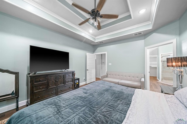 bedroom featuring ornamental molding, visible vents, baseboards, dark wood-type flooring, and a tray ceiling