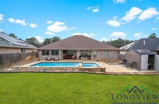 view of swimming pool featuring a fenced in pool, a storage unit, a patio area, a yard, and a fenced backyard