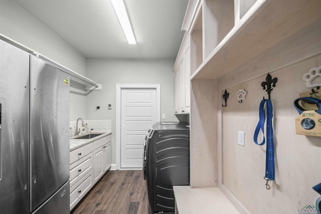 laundry area featuring a sink, dark wood-type flooring, and cabinet space