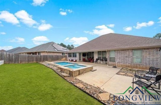 view of swimming pool featuring a lawn, a fenced backyard, a patio, and an in ground hot tub