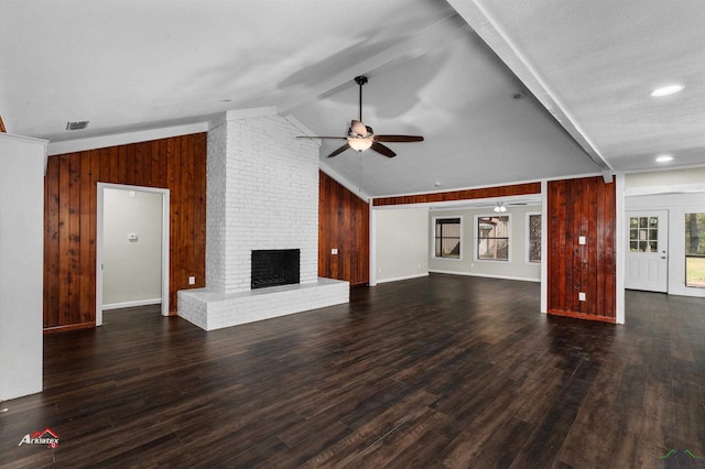 unfurnished living room featuring ceiling fan, wood walls, lofted ceiling, and a fireplace