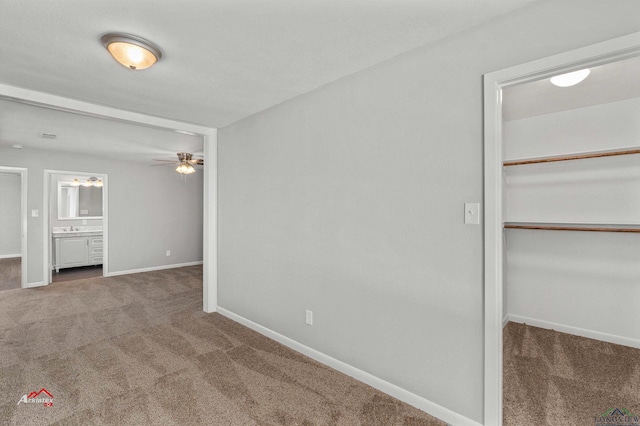 carpeted empty room with ceiling fan and sink