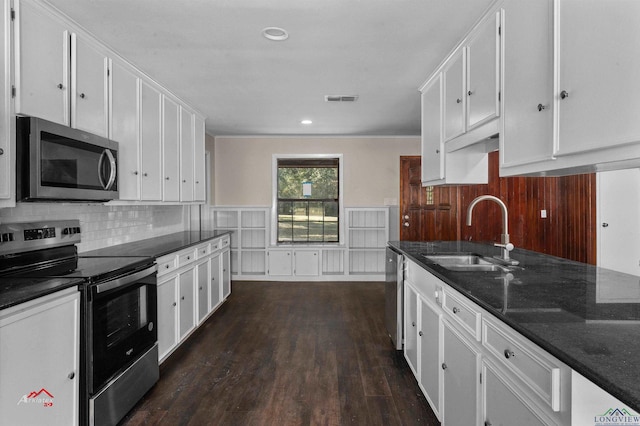 kitchen featuring white cabinets, appliances with stainless steel finishes, dark wood-type flooring, and sink