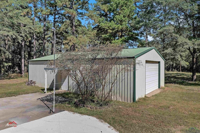 view of outdoor structure featuring a lawn and a garage