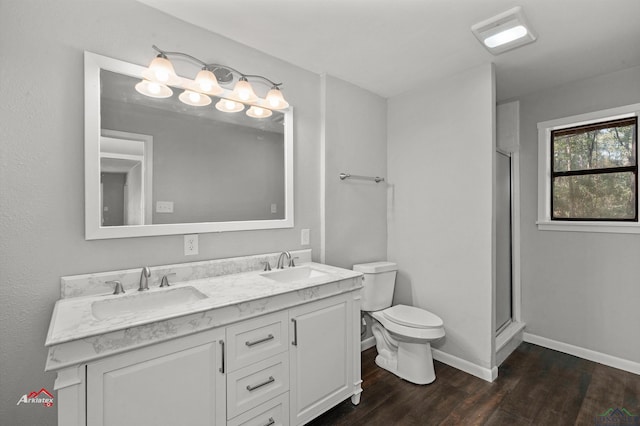 bathroom featuring hardwood / wood-style flooring, toilet, vanity, and walk in shower