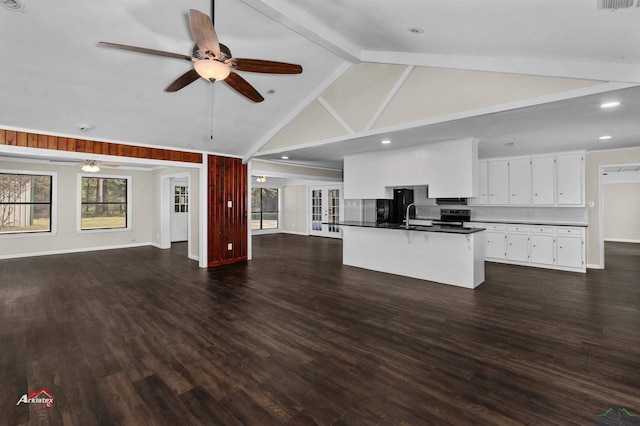 unfurnished living room with vaulted ceiling with beams, ceiling fan, dark wood-type flooring, and sink