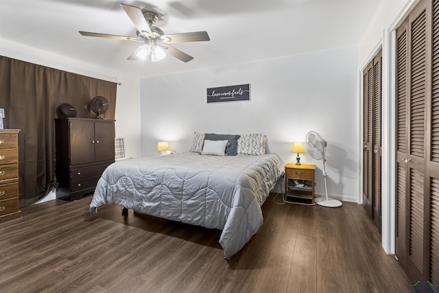 bedroom featuring ceiling fan, dark hardwood / wood-style flooring, and two closets