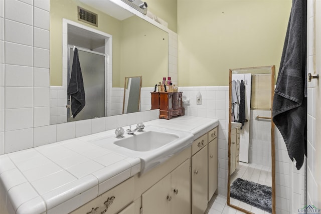 bathroom with tile patterned flooring, vanity, and a shower with shower door