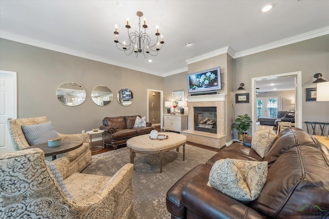 living room with crown molding, a tile fireplace, hardwood / wood-style flooring, and a chandelier