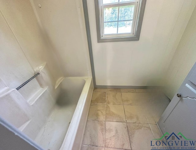 bathroom featuring tile patterned floors and a tub