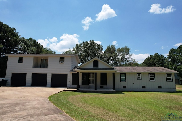 view of front of home with covered porch, a front yard, and a garage