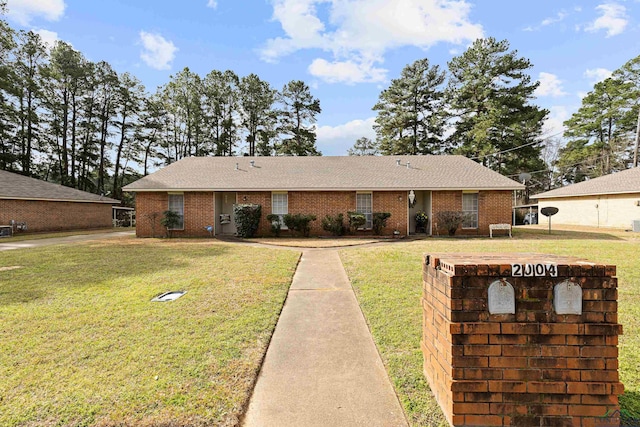 ranch-style home featuring a front lawn and brick siding