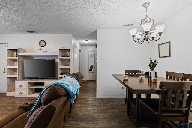 dining room featuring visible vents, a notable chandelier, wood finished floors, and a textured ceiling