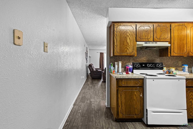 kitchen featuring light countertops, electric stove, under cabinet range hood, a textured ceiling, and backsplash