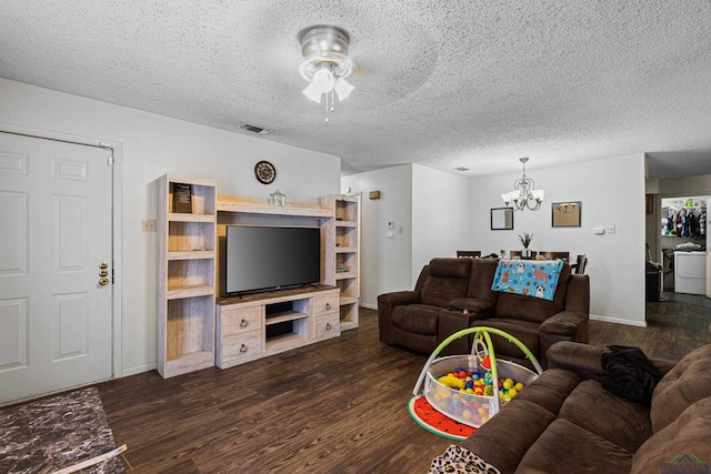 living area featuring visible vents, a textured ceiling, dark wood finished floors, and ceiling fan with notable chandelier