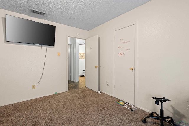 unfurnished bedroom with visible vents, carpet floors, and a textured ceiling