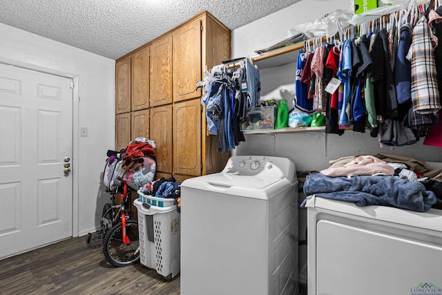 washroom featuring separate washer and dryer, cabinet space, dark wood-type flooring, and a textured ceiling