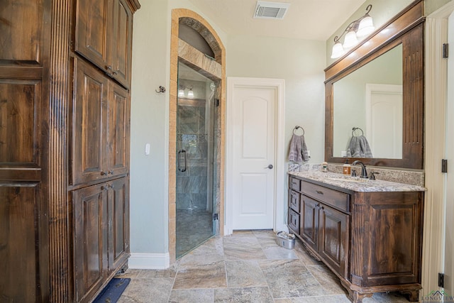 bathroom with vanity and a shower with door