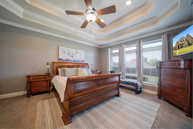 carpeted bedroom with ceiling fan, ornamental molding, and a tray ceiling