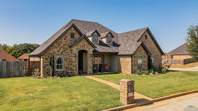 tudor-style house featuring a front lawn