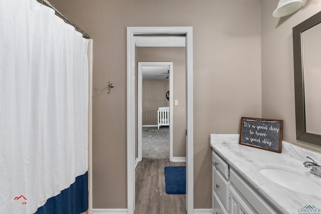 bathroom with hardwood / wood-style floors, vanity, and ceiling fan